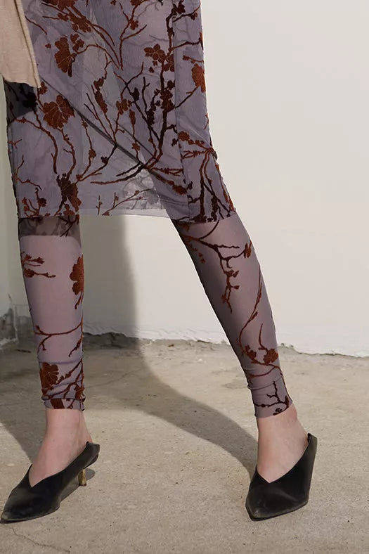 Sheer chiffon leggings with dark branch floral print, mid-calf close-up