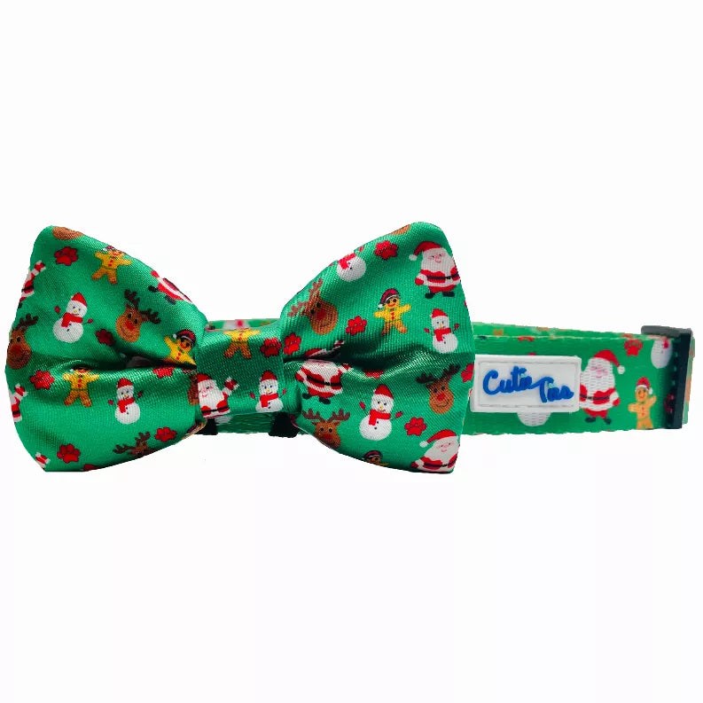 Green dog collar with attached holiday bow featuring Santa and gingerbread print.