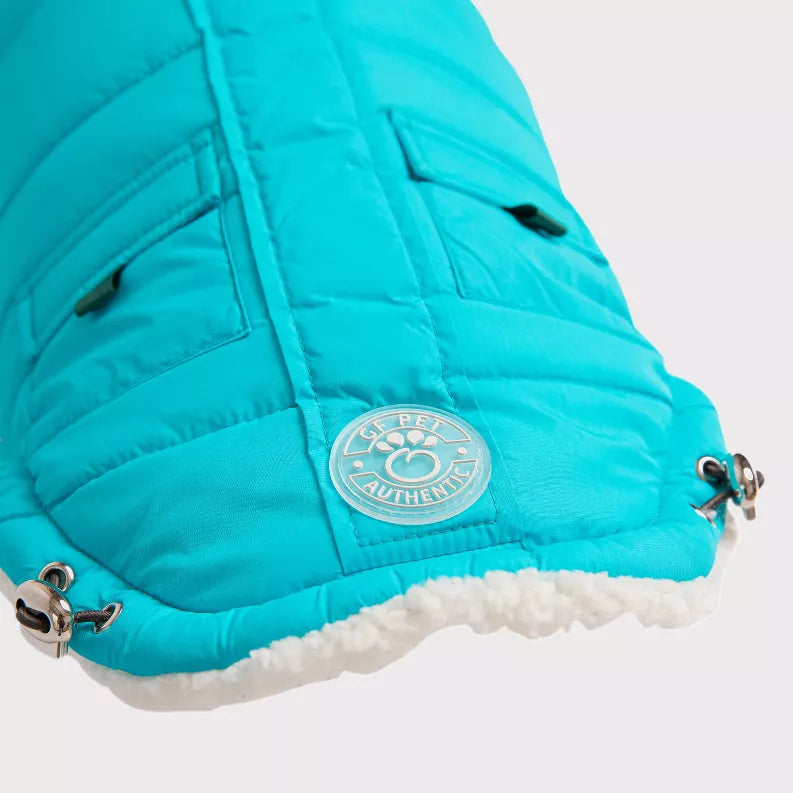 GF Pet winter sailor parka close-up: teal logo badge, sherpa trim, and metal leash rings