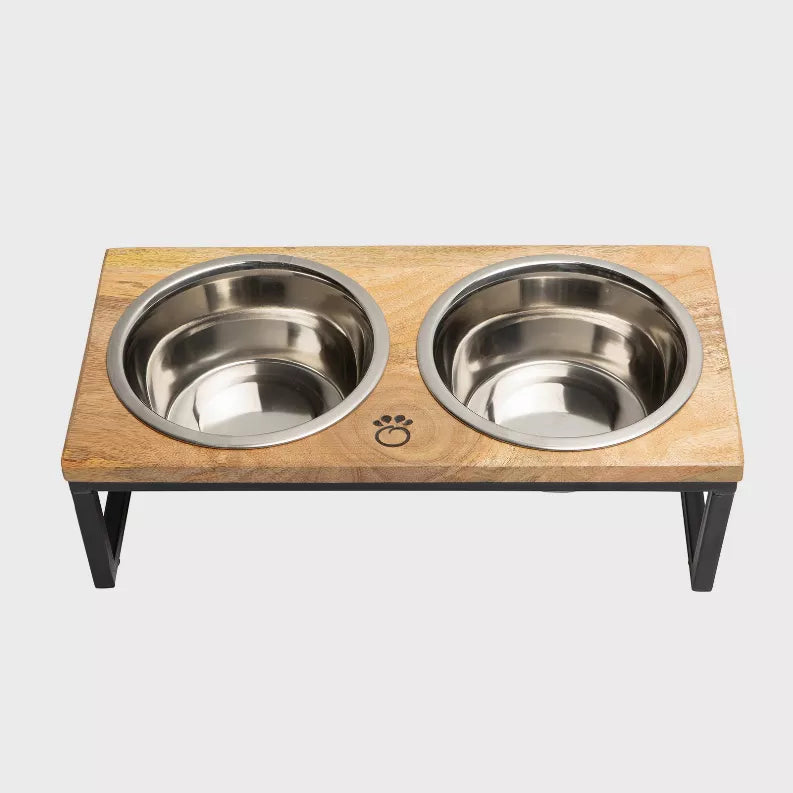 Two stainless steel bowls set in wood feeder base with paw emblem, black legs