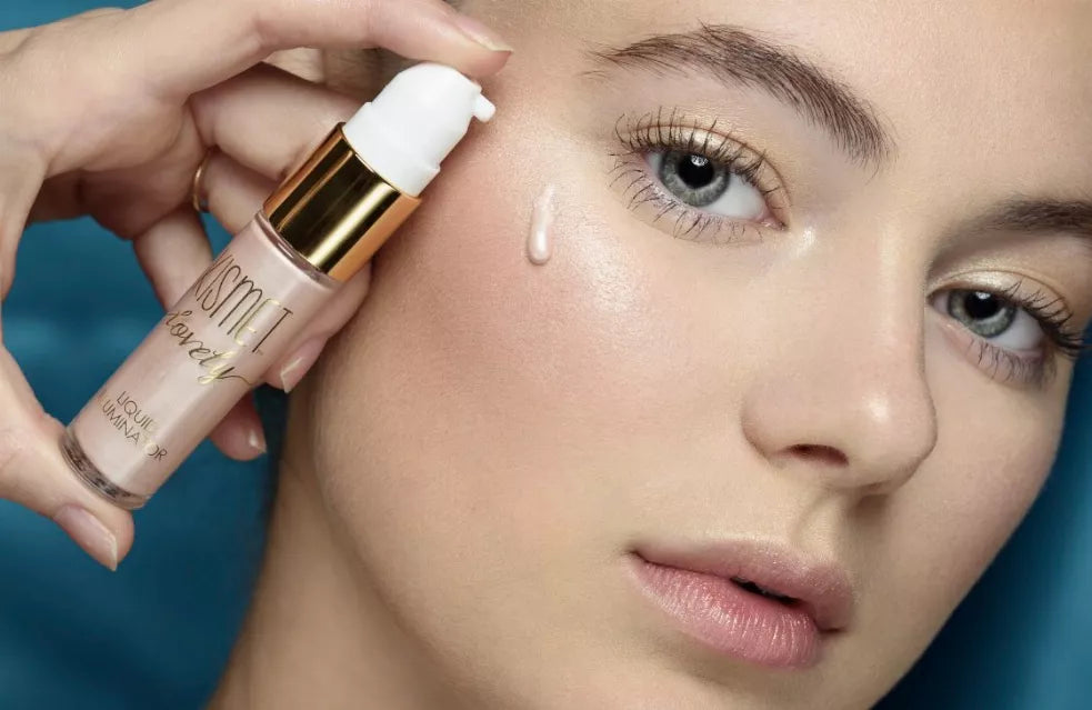 Rose-pink liquid illuminator on skin with pump bottle applying a drop