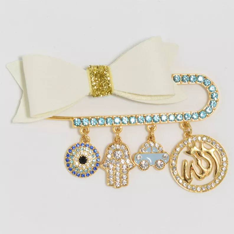 Gold-tone baby pin with cream ribbon bow and blue crystal dangle charms