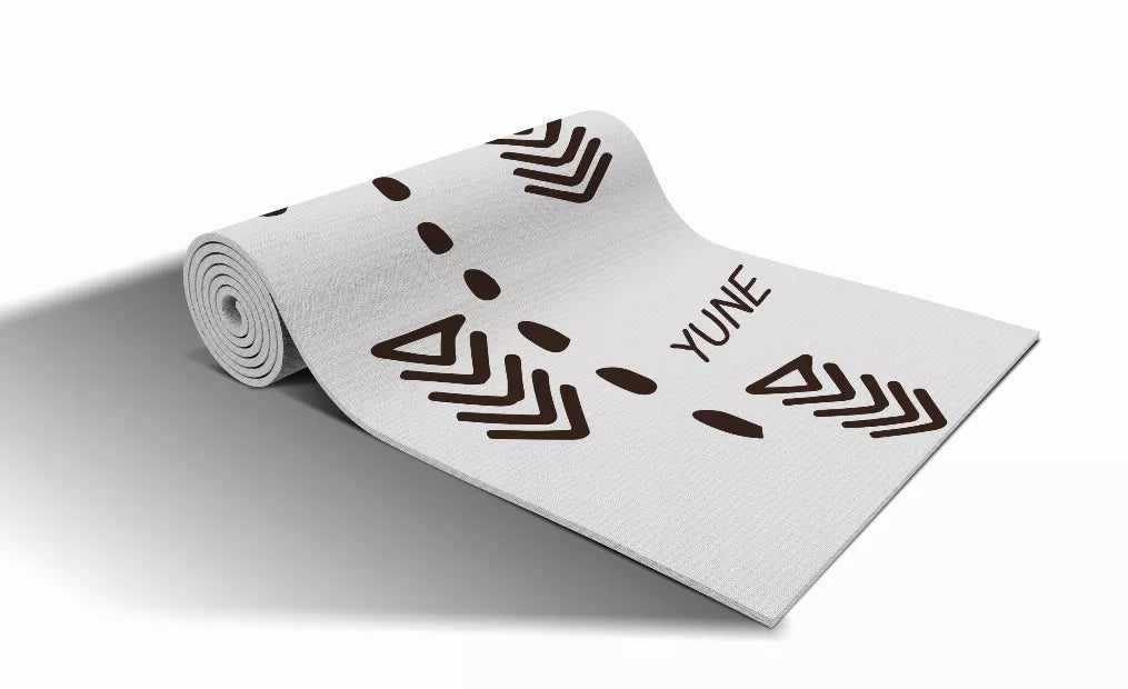 Rolled yoga mat in light gray with dark chevron zigzags and YUNE text
