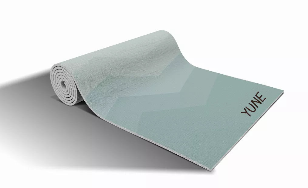 Teal yoga mat with rolled design, zigzag pattern, YUNE branding at corner