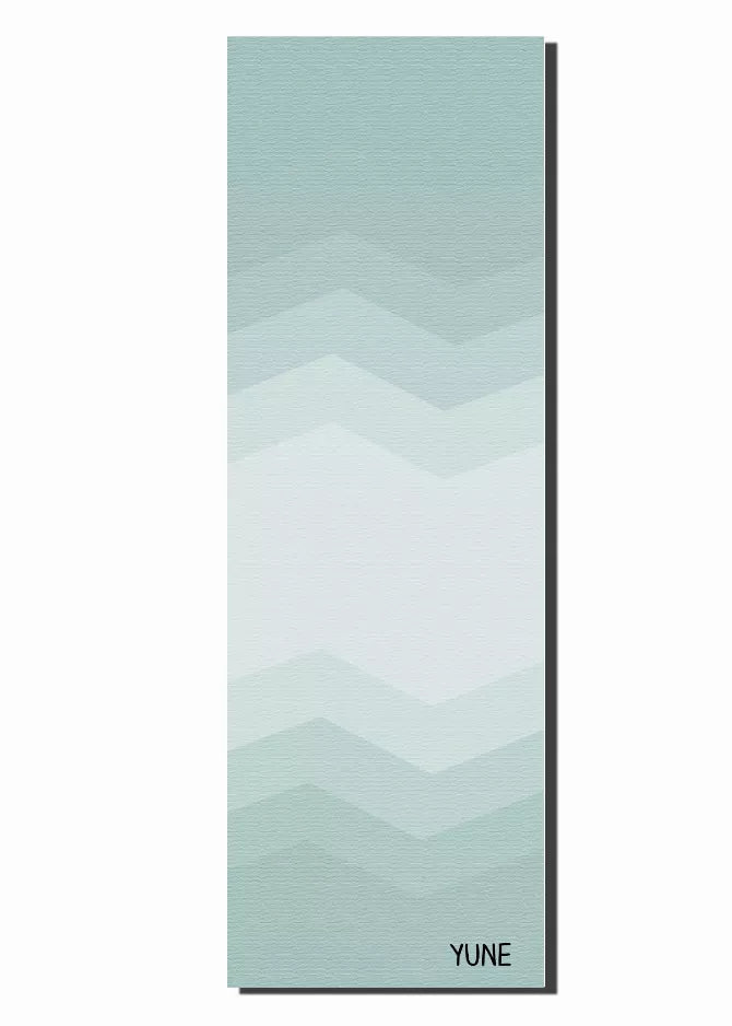 Teal yoga mat laid flat with light chevron zigzag pattern and YUNE logo bottom right