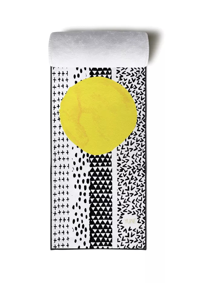 Yoga towel folded flat with black-and-white geometric print and yellow circle