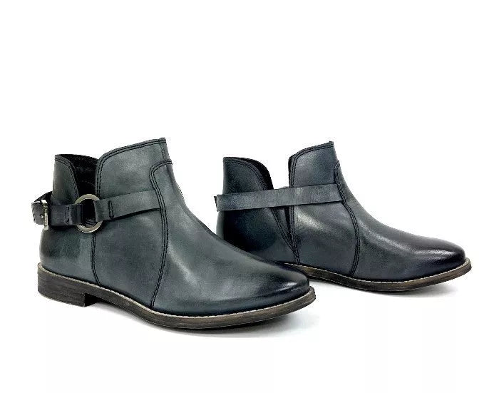 Pair of dark teal ankle booties with buckled strap and elastic gore panels