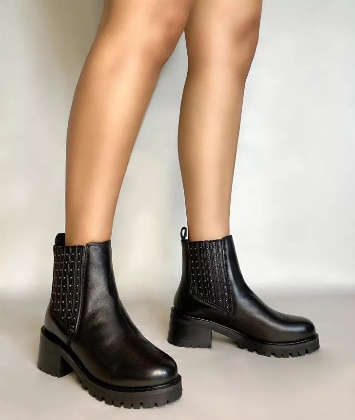 Black studded platform chelsea ankle boots on legs with chunky block heels