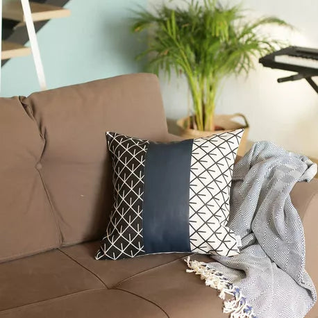 Square geometric throw pillow with navy center panel and black-and-white lattice design