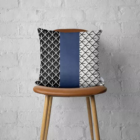 Square geometric throw pillow with navy faux-leather center stripe and black/white lattice