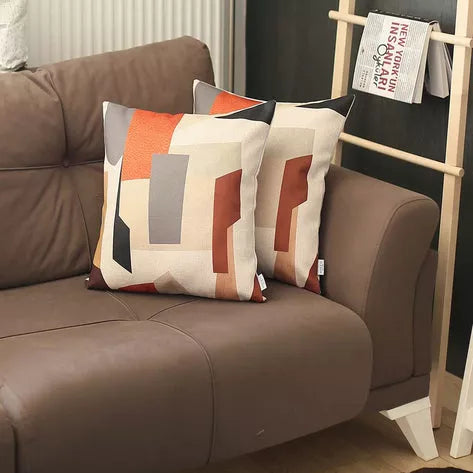 Printed throw pillow cover on sofa, white with geometric orange and gray blocks