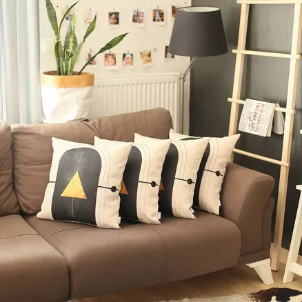 Printed throw pillow covers: black arch, gold tree, striped base (shown on sofa)