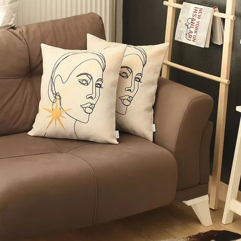 Set of two white printed pillow covers with line-art faces and gold starburst design