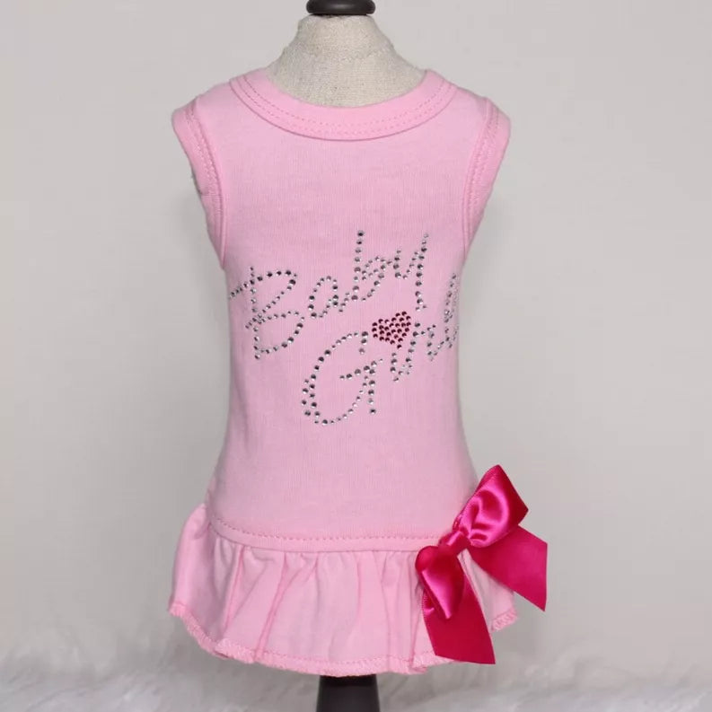 Pink sleeveless baby dress with rhinestone lettering and red satin bow at waist