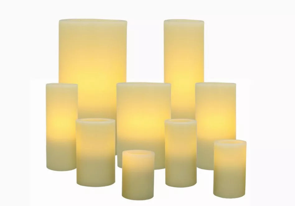 Ivory flameless wax pillar candles, glowing wax cylinders in varied heights