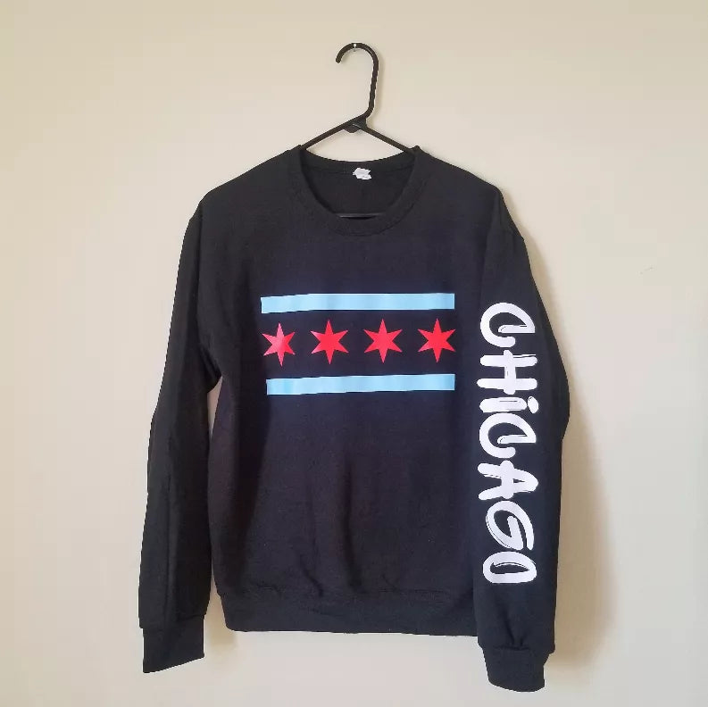 Black crewneck sweatshirt on hanger with flag graphic, red stars, blue stripe, and white side text