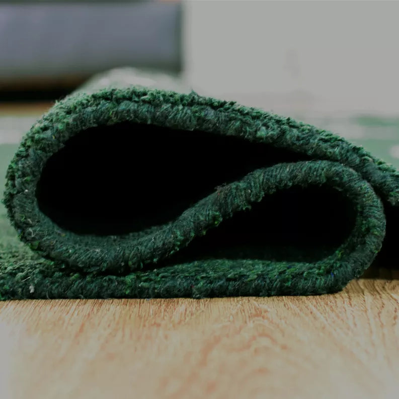 Green area rug rolled edge with plush pile and white motif design