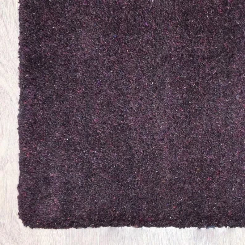 Purple hand-knotted rug close-up with dense textured pile and subtle speckling
