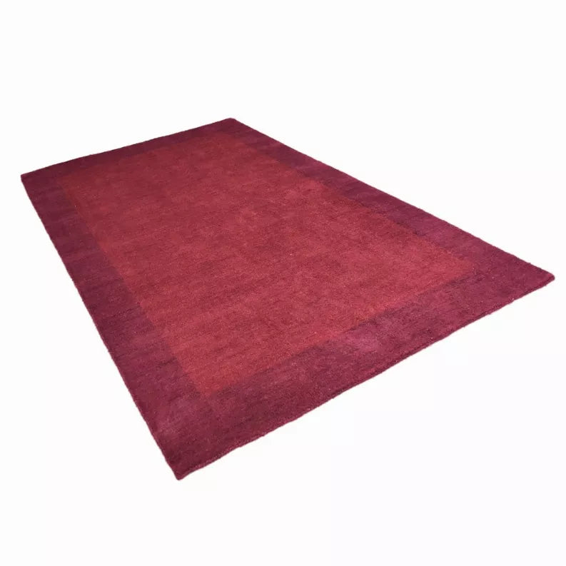 Hand-knotted silk blend area rug, maroon solid with subtle sheen and textured pile.