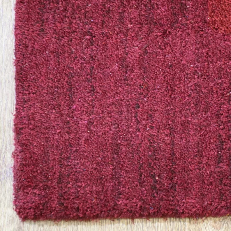Close-up of burgundy rug corner with low pile texture