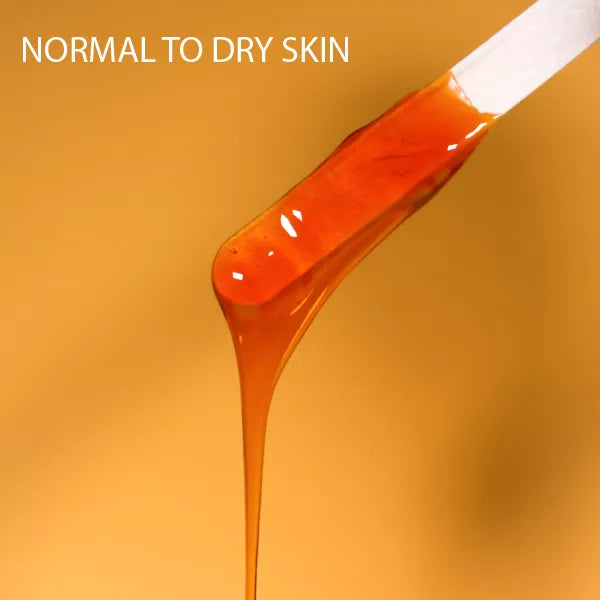 Orange amber hard wax applied in a smooth strip from a spatula