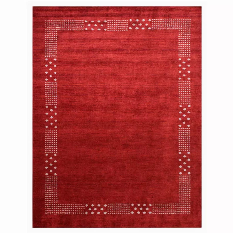 Red area rug with cream outlined border of small diamond dots and central medallion frame.