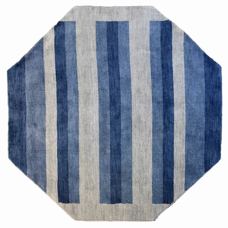 Octagon area rug with vertical stripe pattern in blue, gray, and cream tones