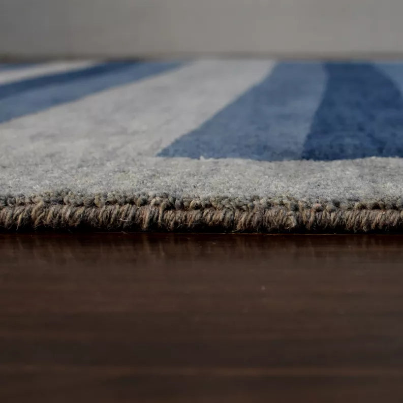 Close-up of rug border and low-pile edge on blue and gray striped octagon rug