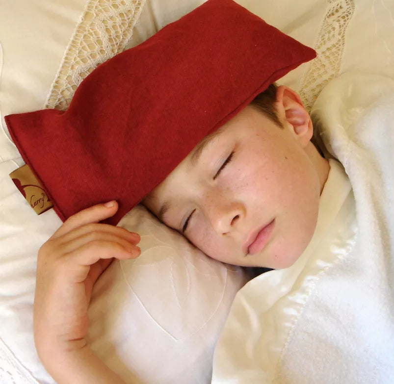 Red suede eye pillow, rectangular shape with stitched edges for facial cooling comfort.