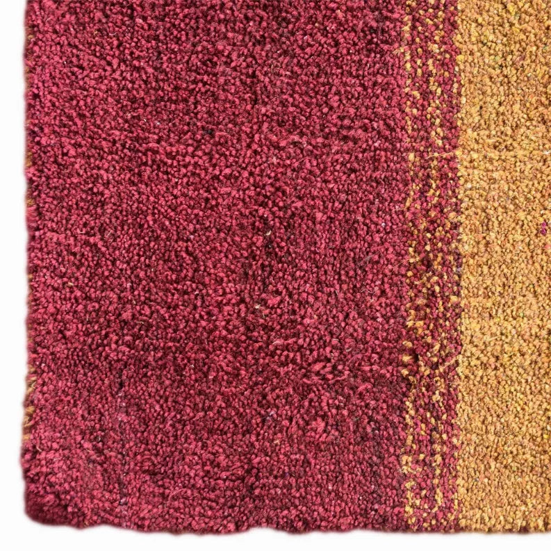 Hand-knotted shag rug with dense deep red pile and a gold border stripe.
