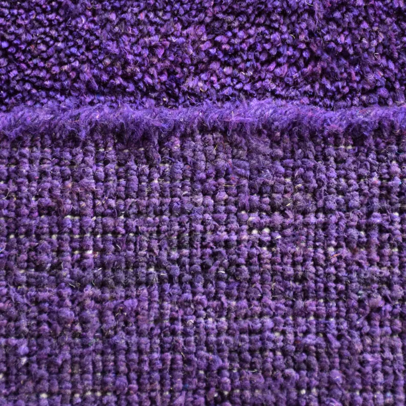 Close-up of purple rug pile with dense, textured fibers