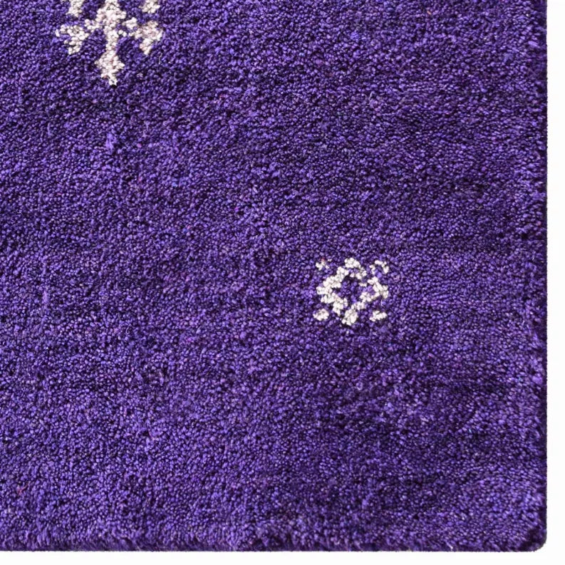 Purple rug close-up showing dense texture with small white motif details