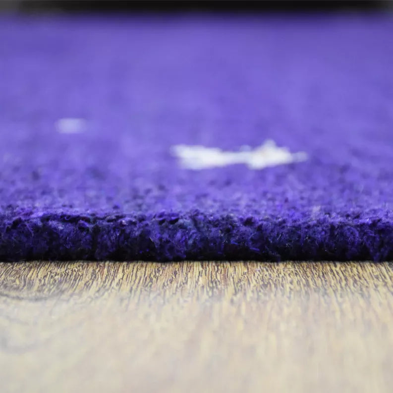 Purple rug edge close-up with short dense pile and light backing