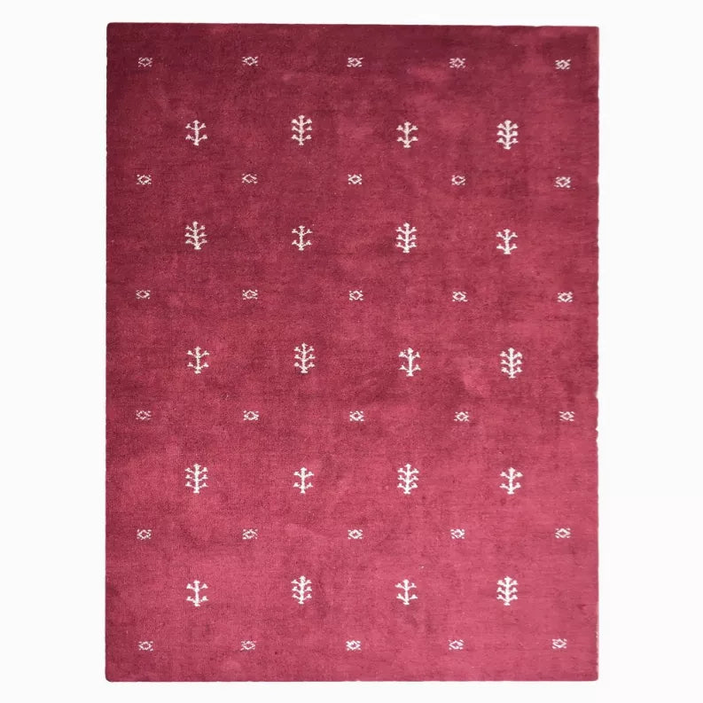 Burgundy patterned area rug with repeating white geometric motifs, centered studio view