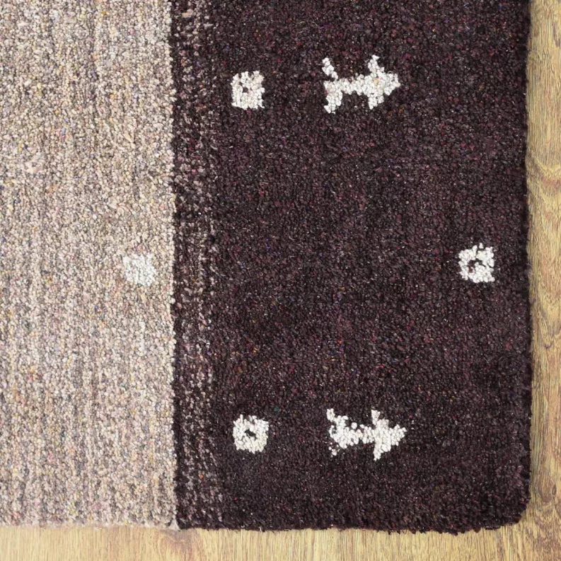 Area rug close-up of dark panel with cream cross motifs and faint pattern speckling texture.