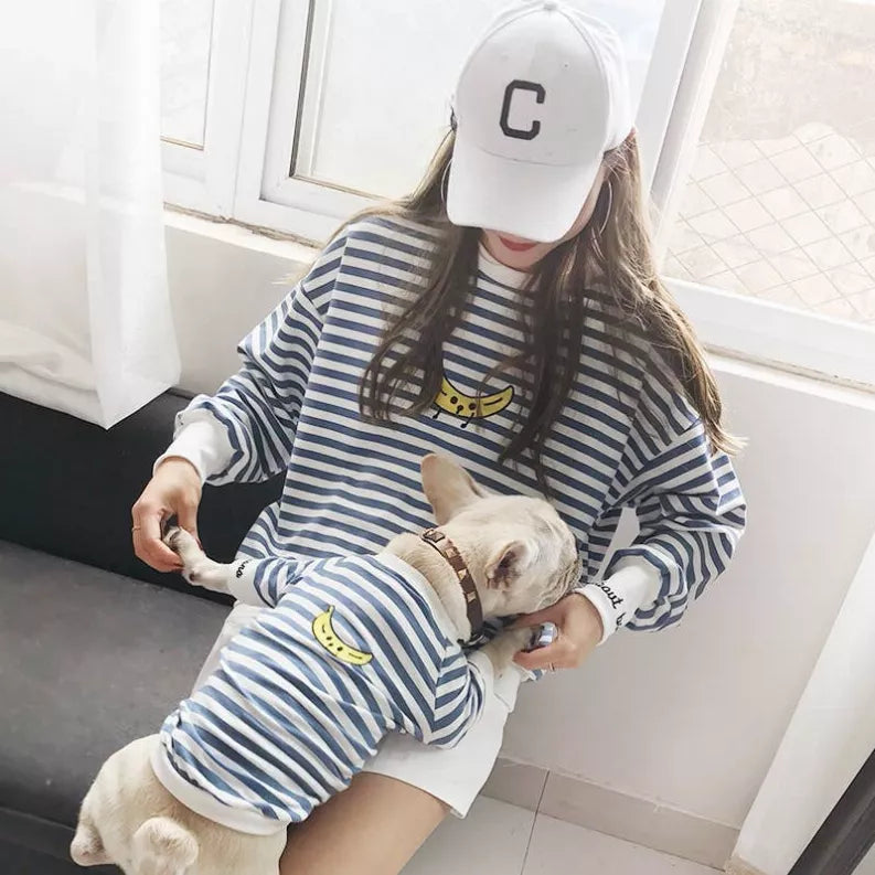 Blue-and-white striped long-sleeve pet outfit with yellow graphic, dog being held