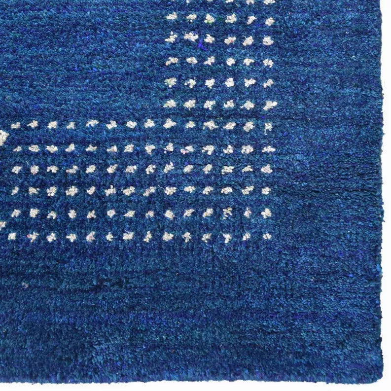 Blue area rug close-up with repeating white diamond dash pattern