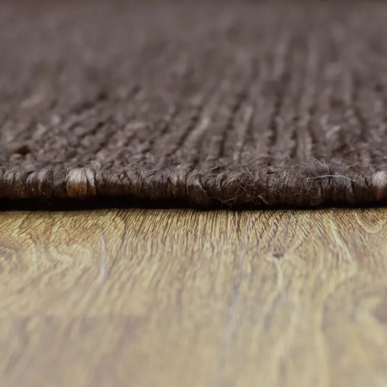Brown jute area rug with short pile and textured edge