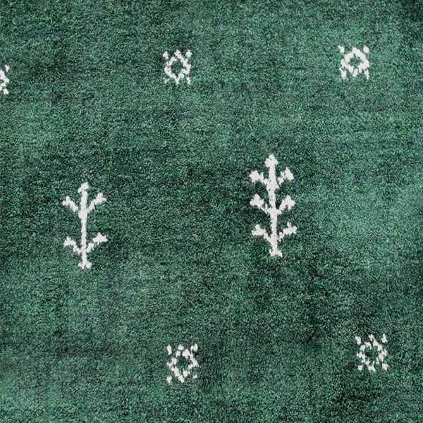 Green area rug with white geometric trellis motifs, textured short pile surface