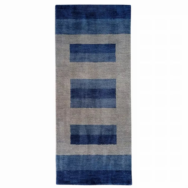 Hand-knotted wool runner rug with navy and blue block pattern on gray