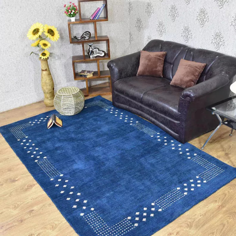 Blue area rug with white diamond lattice border, rectangular geometric center
