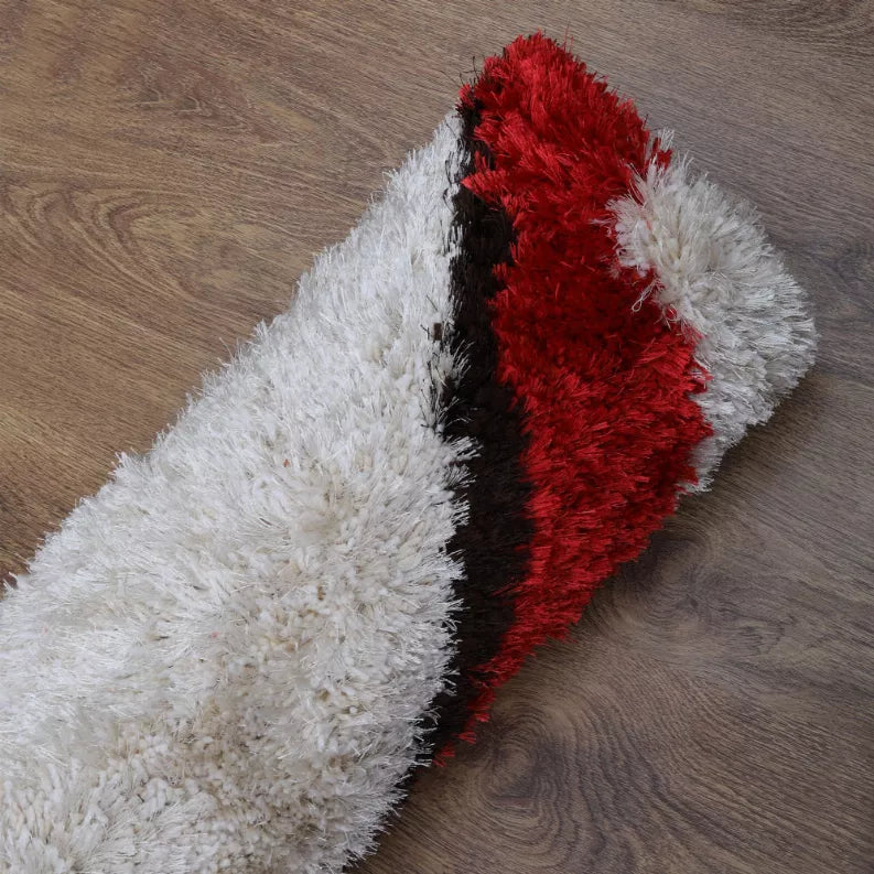 Shag area rug with long white pile, red stripe, and black band detail