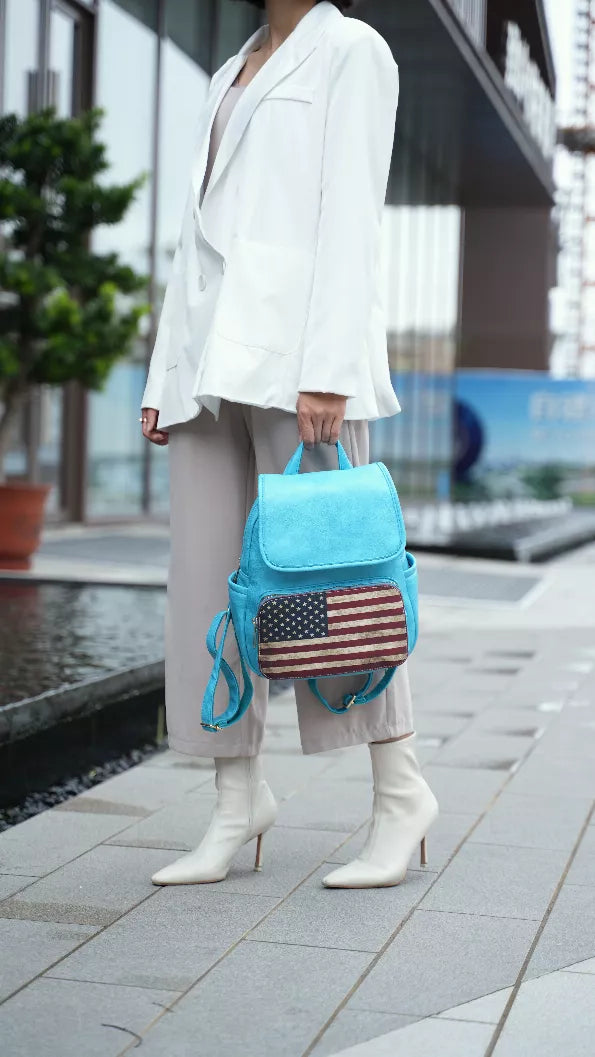 Turquoise mini backpack with American flag patch, top flap, and drawstring side ties.