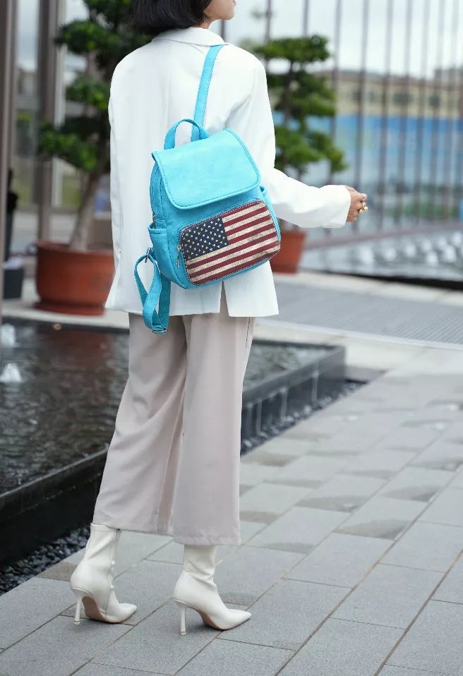 Turquoise mini backpack worn from the side, with American flag front patch and flap.