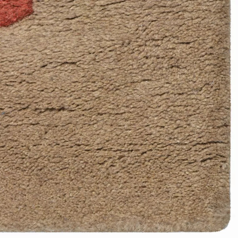 Hand-tufted wool area rug corner with dense beige looped texture