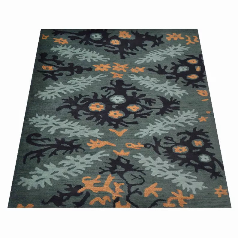 Hand-tufted wool area rug, centered floral foliage design in teal-gray, navy, and orange