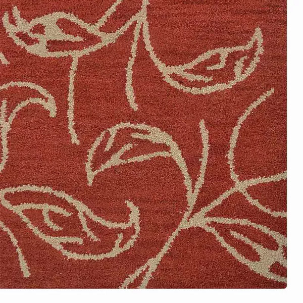 Rust red area rug with cream floral vine pattern and distressed detailing.