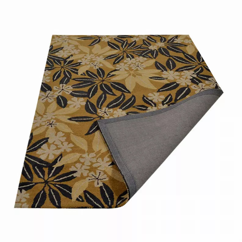 Hand-tufted wool floral area rug, folded with gray underside; beige and dark navy pattern