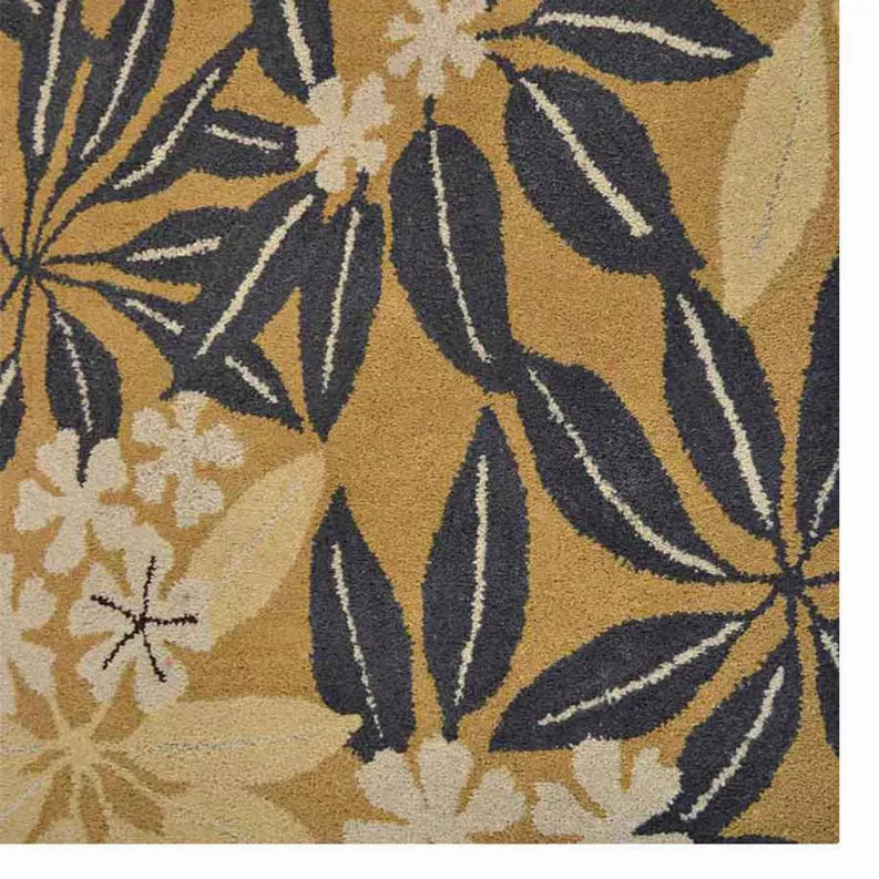 Close-up of hand-tufted wool floral rug: beige background with dark navy botanical motifs