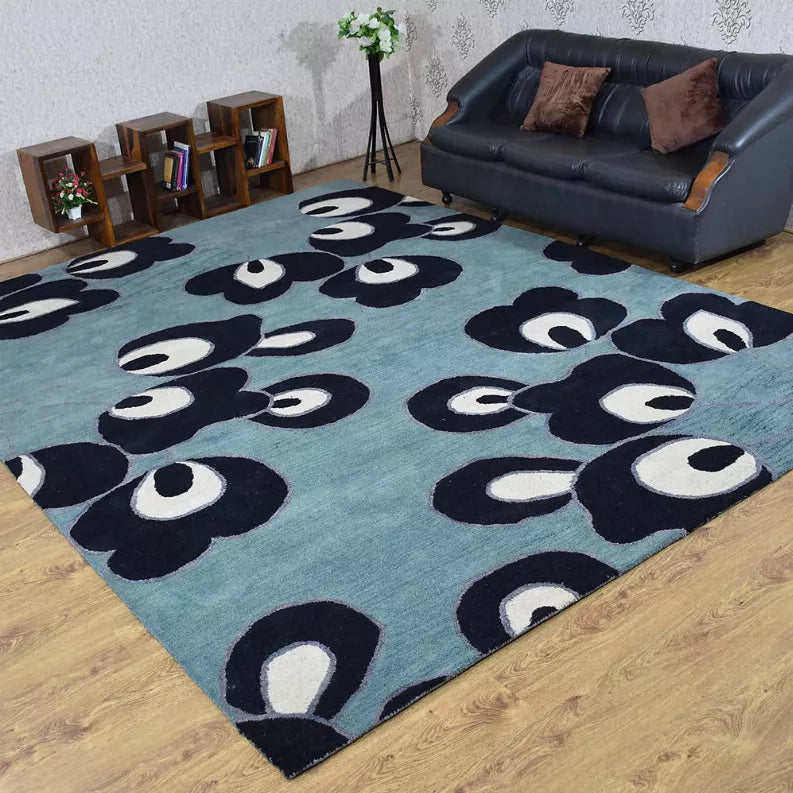 Blue floral area rug with dark navy and white flower pattern on wood floor